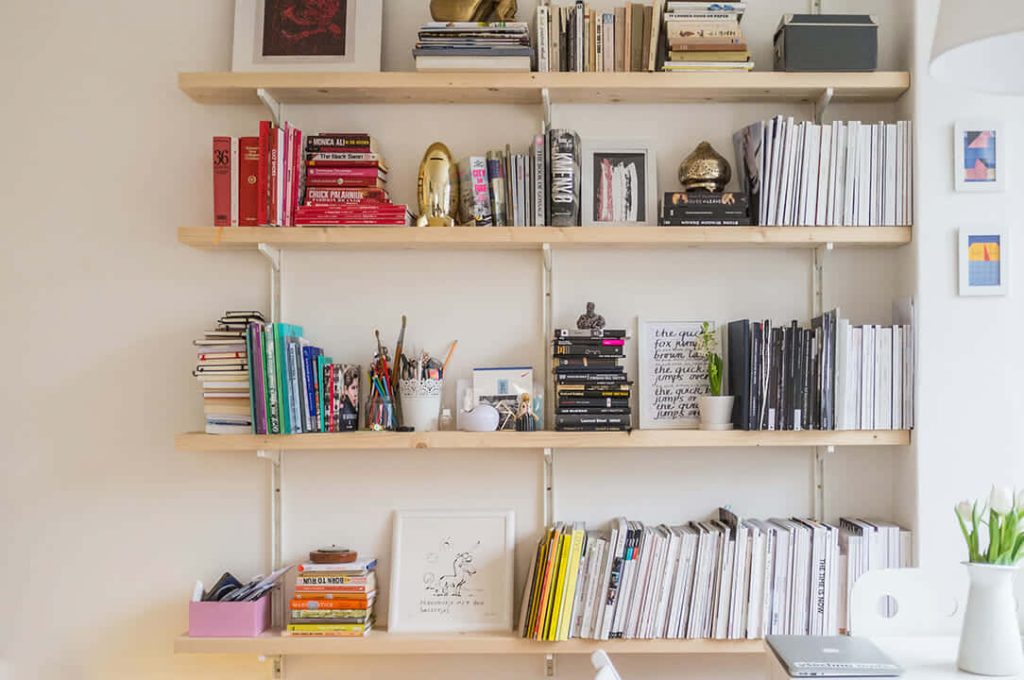 Bright virtual Zoom wallpaper with wooden shelves books art cozy decor clean office background