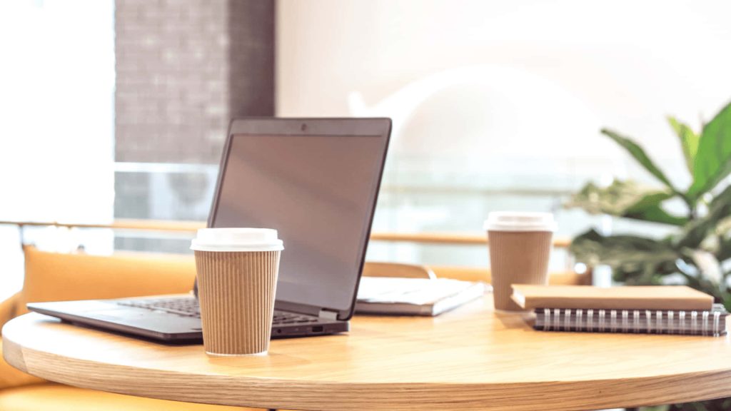 Bright Zoom wallpaper with open laptop coffee cups and notebooks on wooden table