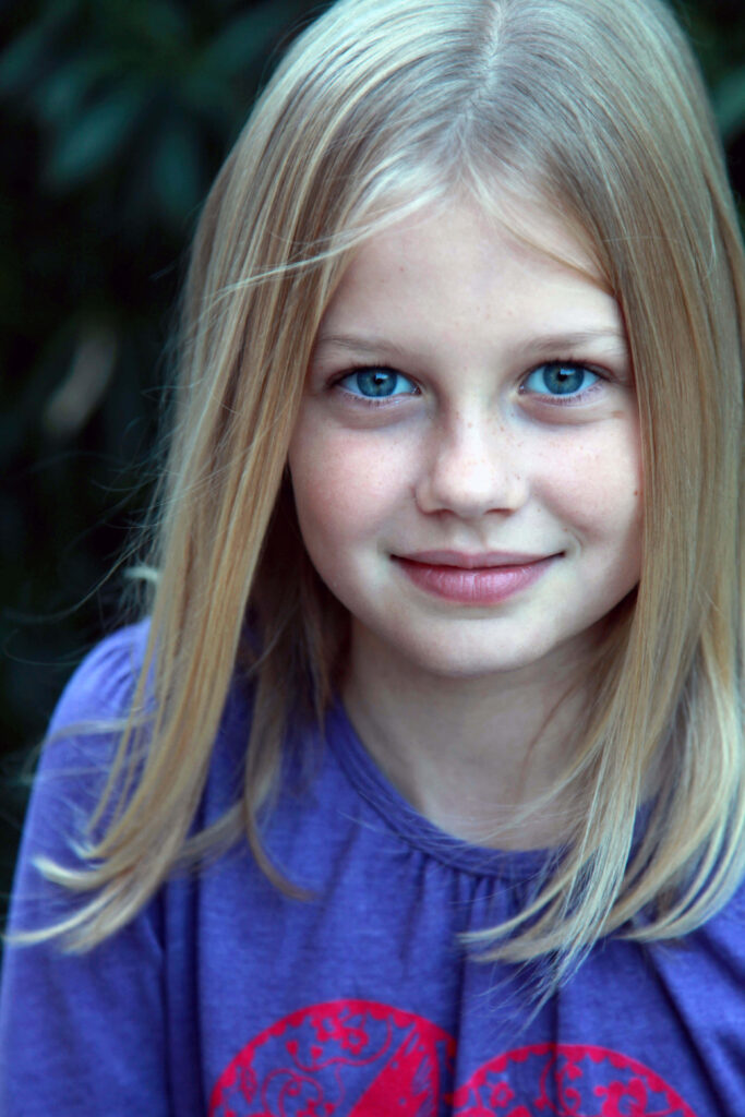 Young Angourie Rice smiling with bright blue eyes and natural blonde hair wallpaper background