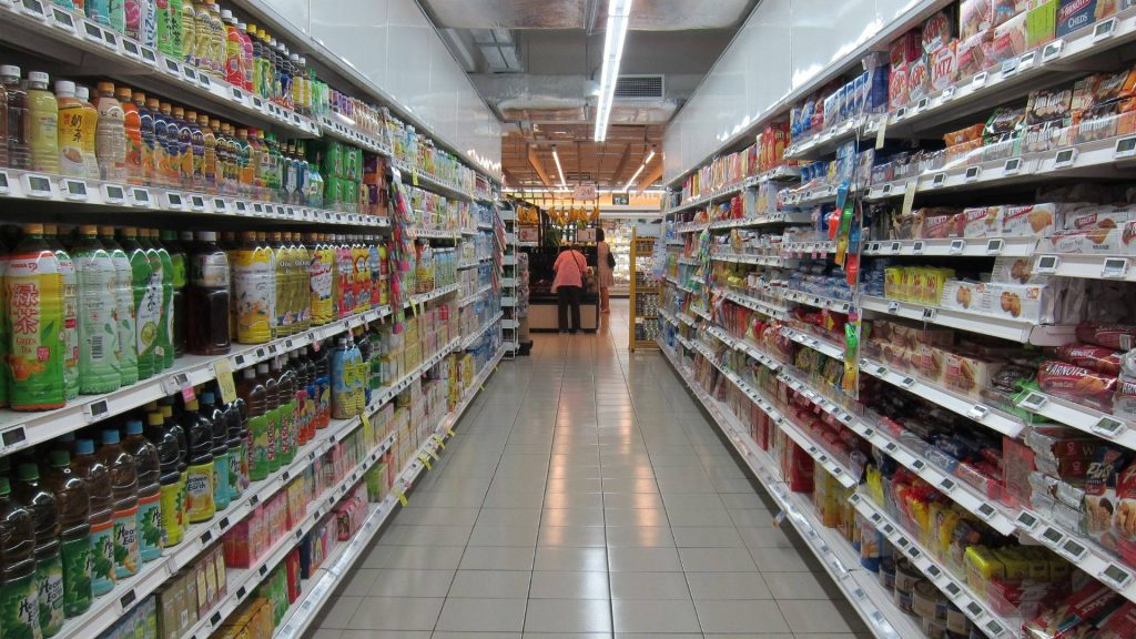 Bright supermarket aisle with colorful bottled tea Arnold's biscuits clean reflective floors wallpaper