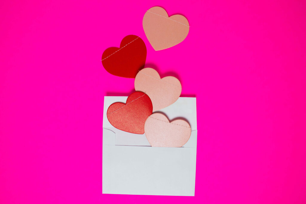 Cheerful Wallpaper: White Envelope with Colorful Hearts on Pink