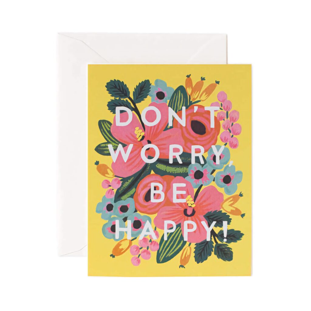 Bright yellow floral wallpaper with colorful flowers and white block letters saying Don't Worry Be Happy