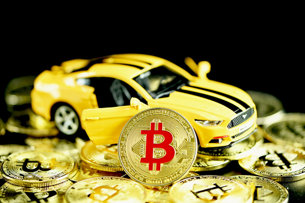 Bright yellow toy car with gold Bitcoin coins symbolizing crypto and automotive ambition wallpaper