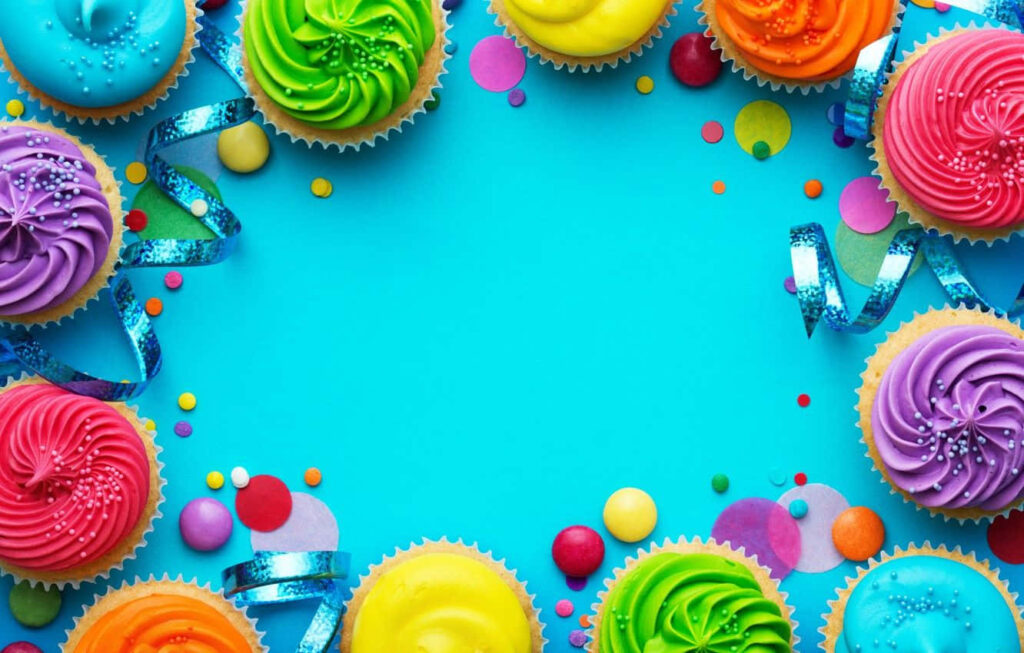 Joyful Cupcake Wallpaper: Colorful Celebration on Blue Background