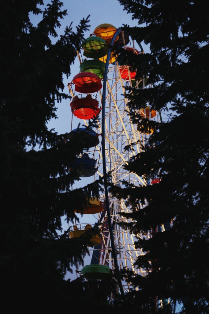 Enchanting Ferris Wheel Wallpaper: Vibrant Night Scene with Silhouetted Trees