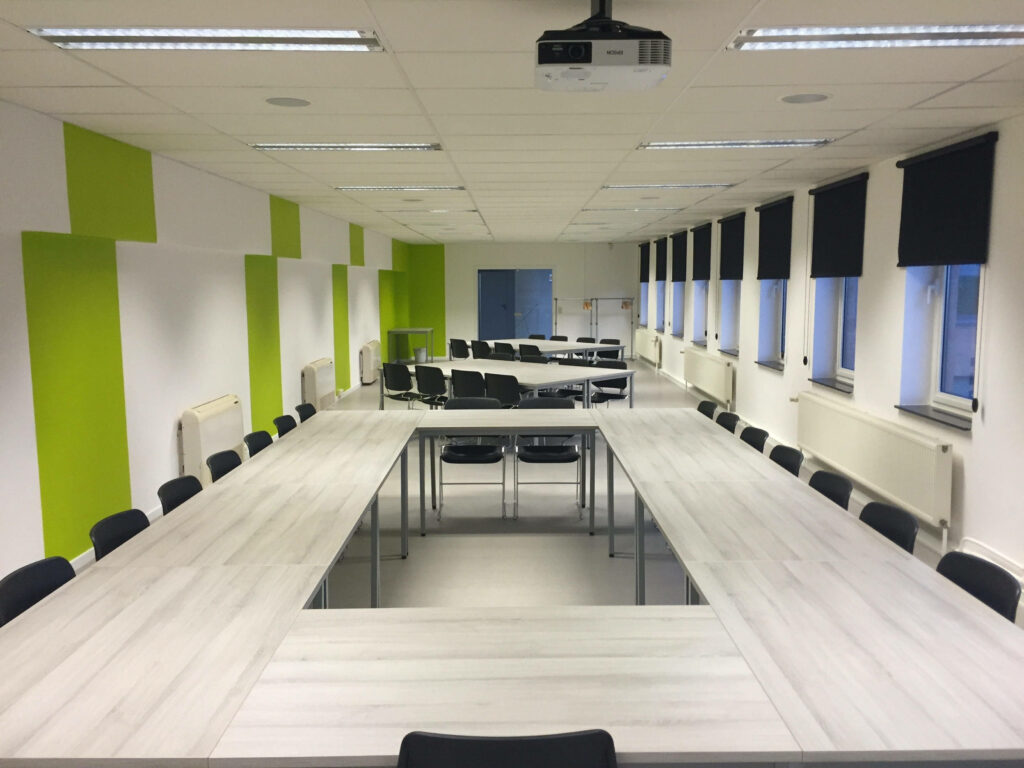 Vibrant Boardroom: Colorful Zoom Background with Rectangular Table and Light Green Walls Wallpaper