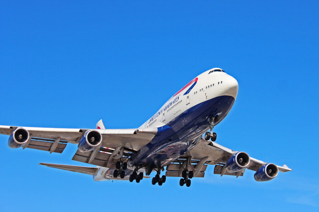 British Airways airplane bottom view soaring blue sky powerful engines landing gear wallpaper