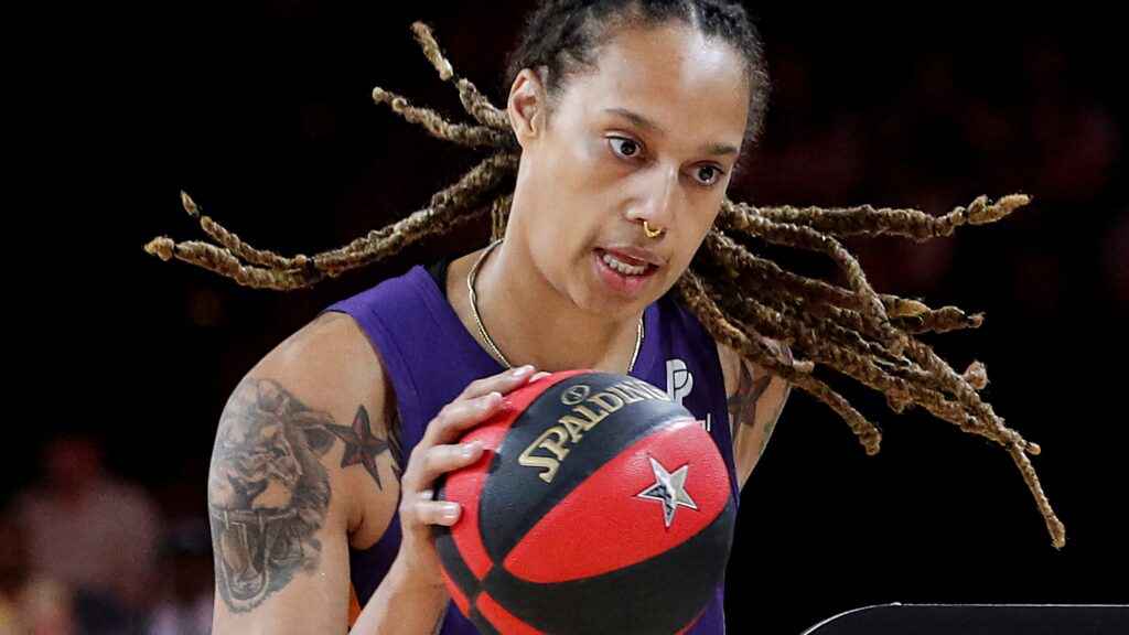 Brittney Griner WNBA star holding basketball red black wallpaper showcasing athletic intensity