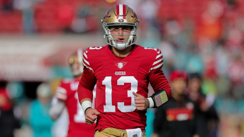 Brock Purdy 49ers quarterback number 13 in red gold uniform action football wallpaper background