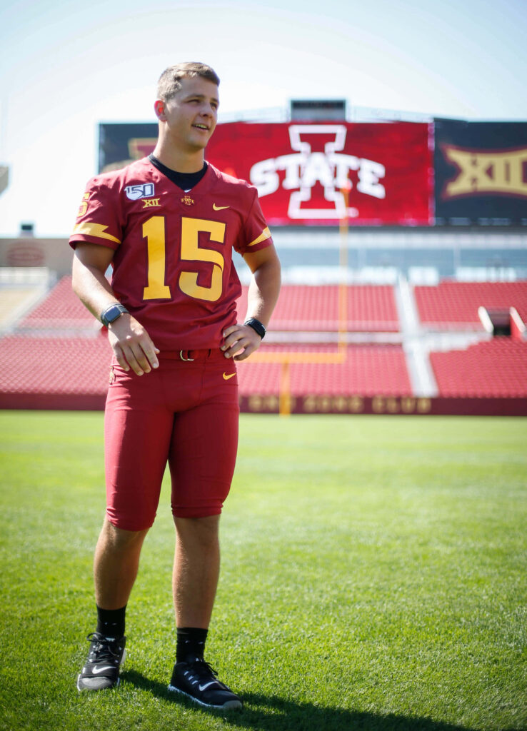 Brock Purdy in Iowa State football uniform on field with cardinal gold colors and stadium background Wallpaper