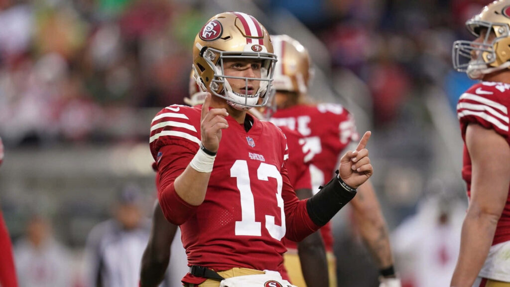 Brock Purdy San Francisco 49ers quarterback signaling on field vibrant game day wallpaper
