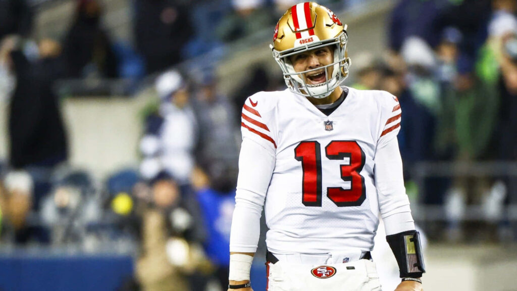 Brock Purdy San Francisco 49ers quarterback smiling on field in white and red uniform wallpaper