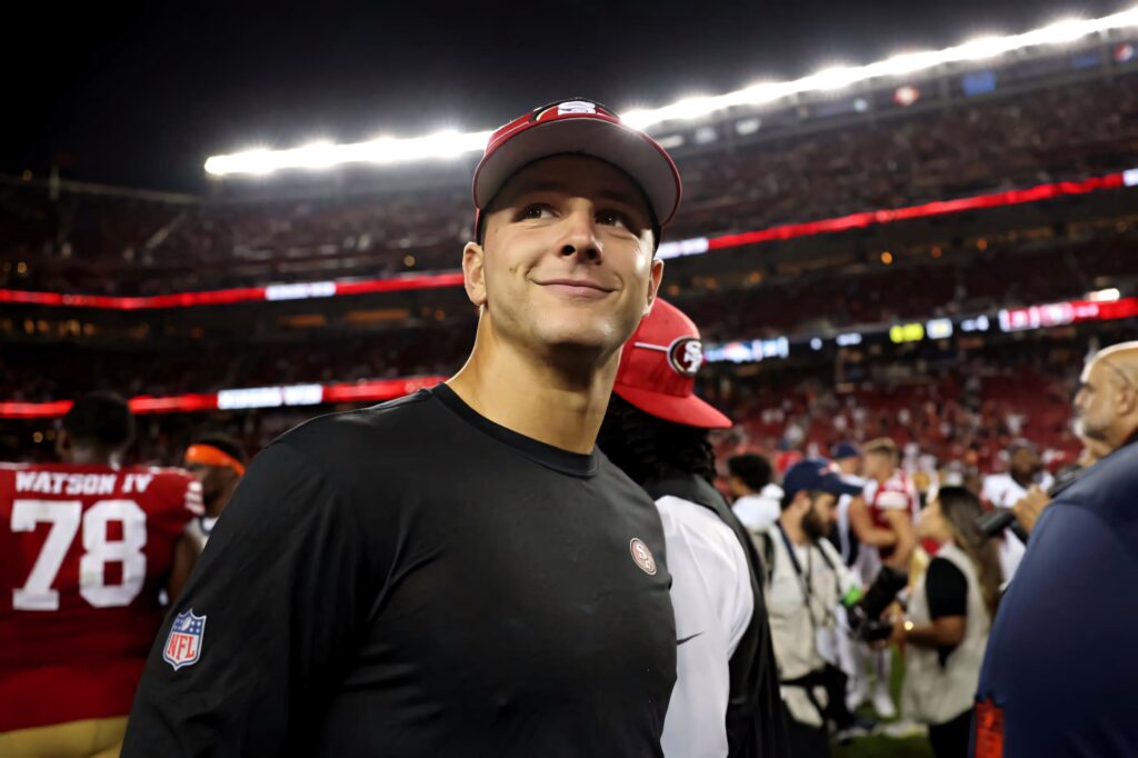 Brock Purdy smiling San Francisco 49ers quarterback post game vibrant stadium wallpaper background