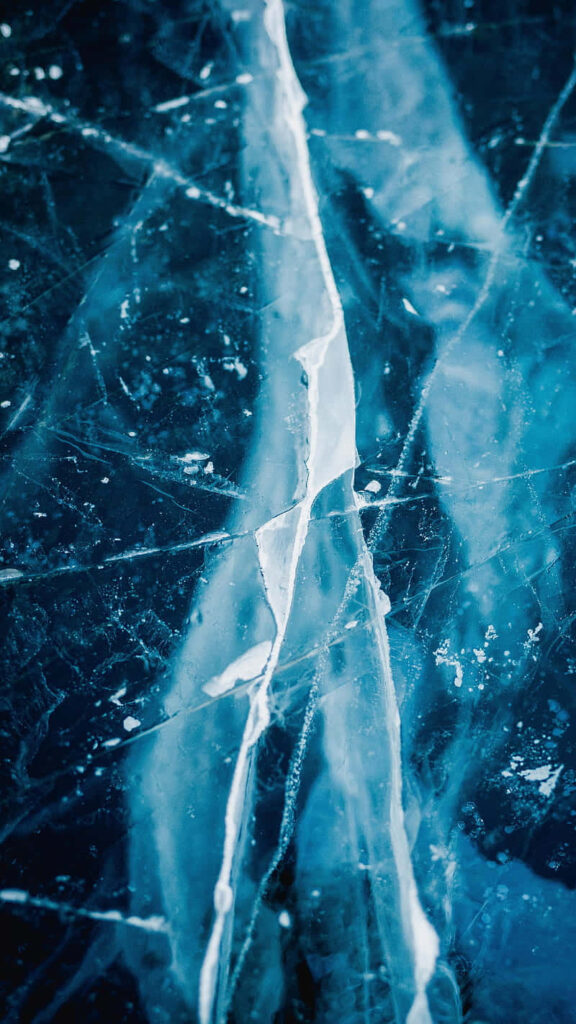 Broken glass background with jagged cracks and sharp lines on a vibrant blue modern wallpaper