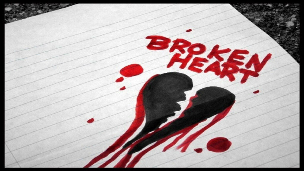 Hand-drawn black and red broken heart bleeding on notebook paper with bold text and ink drops Wallpaper