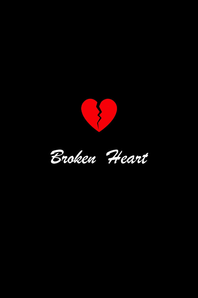 Broken red heart split in center on black background with white Broken Heart text wallpaper