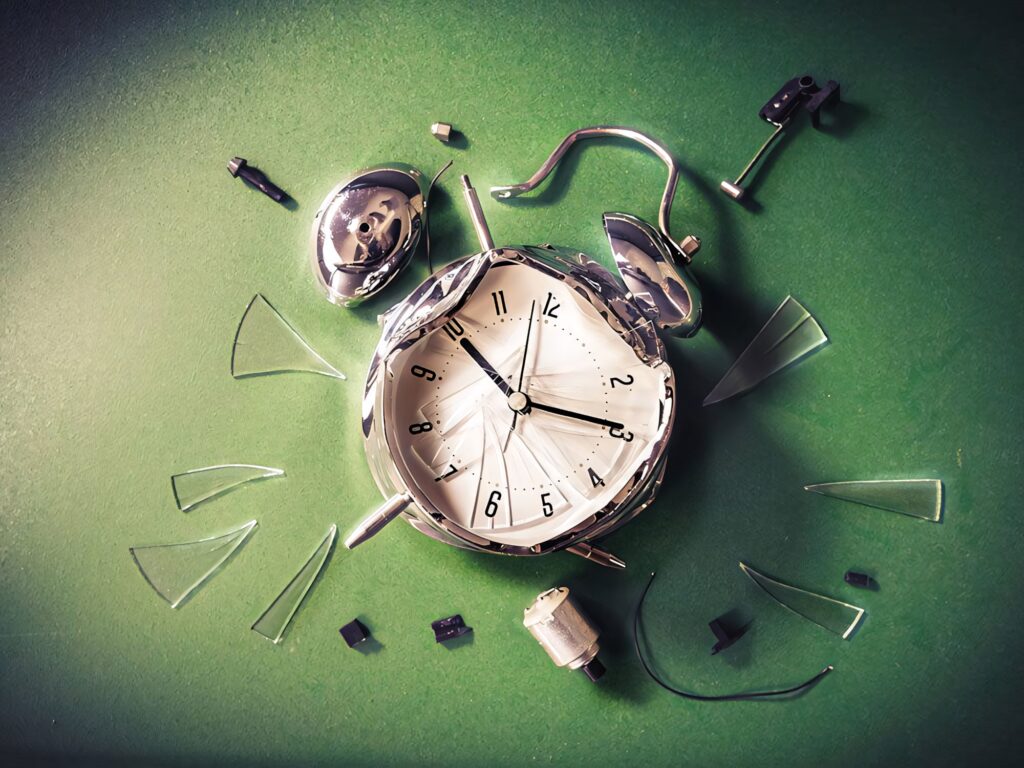Broken vintage clock with shattered glass on green background symbolizing lost time chaos Wallpaper