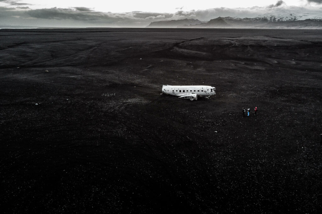 Desolate Landscape: Decaying Remains of an Abandoned Airplane Wallpaper