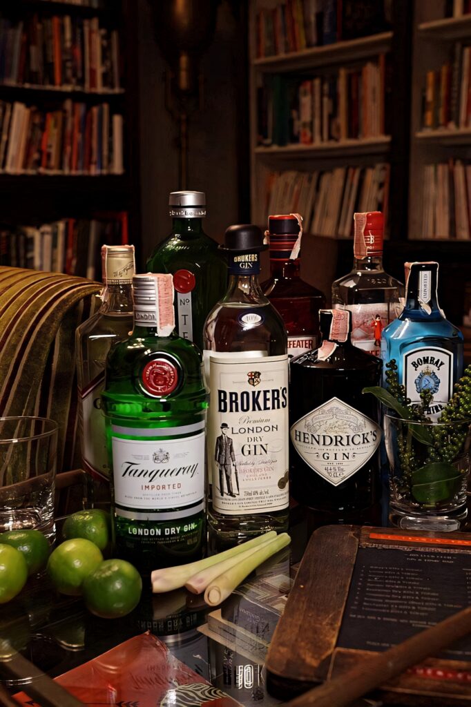 Stylish Broker's Gin cocktail setup with premium gins fresh limes lemongrass and glassware Wallpaper