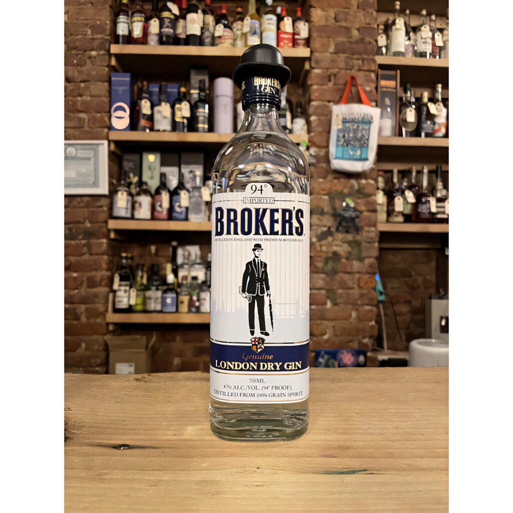 Broker's Gin bottle on rustic wood table with brick wall and liquor bottles in warm light Wallpaper
