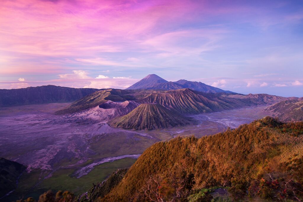 Bromo volcano on Java Island with blue pink sky and rolling hills volcanic landscape wallpaper