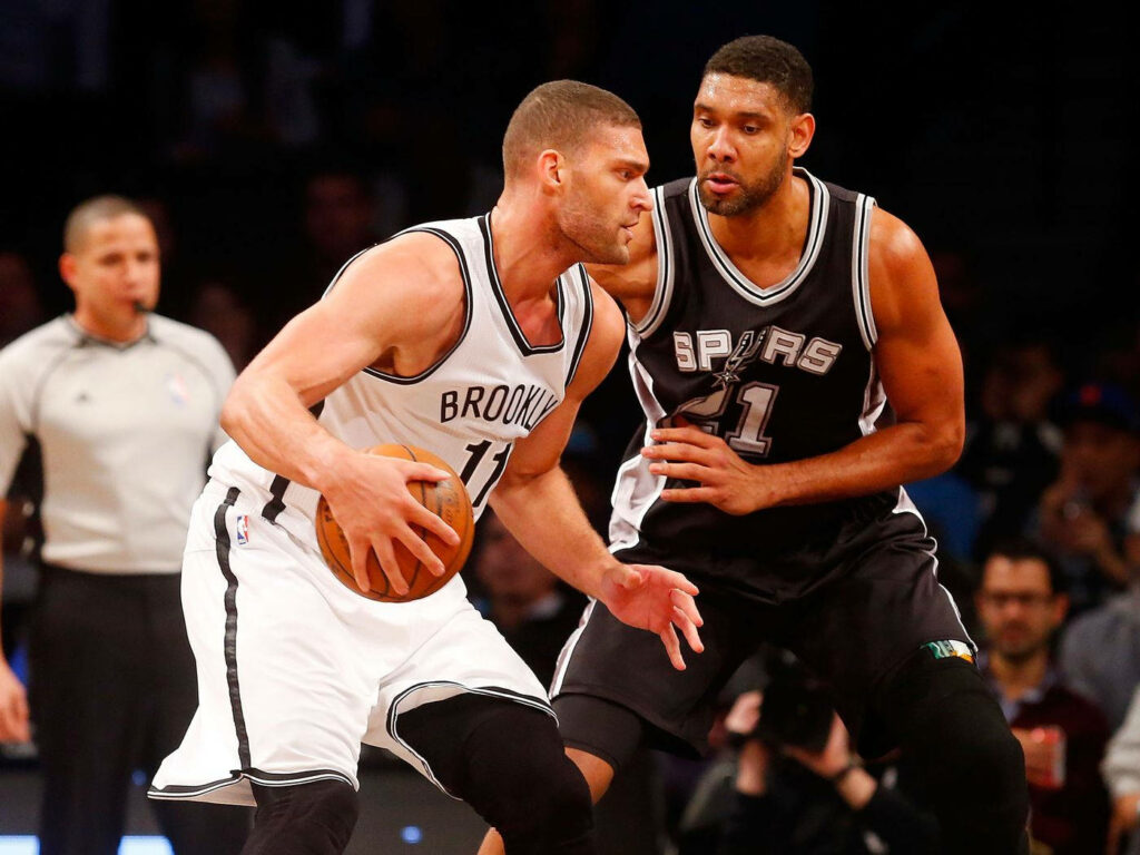 Brook Lopez driving past Tim Duncan NBA intense basketball action Brooklyn Nets Spurs wallpaper