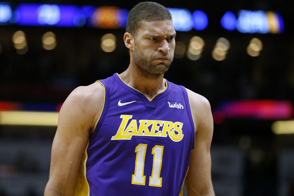 Brook Lopez focused in Lakers jersey 11 with intense look in vibrant basketball arena wallpaper