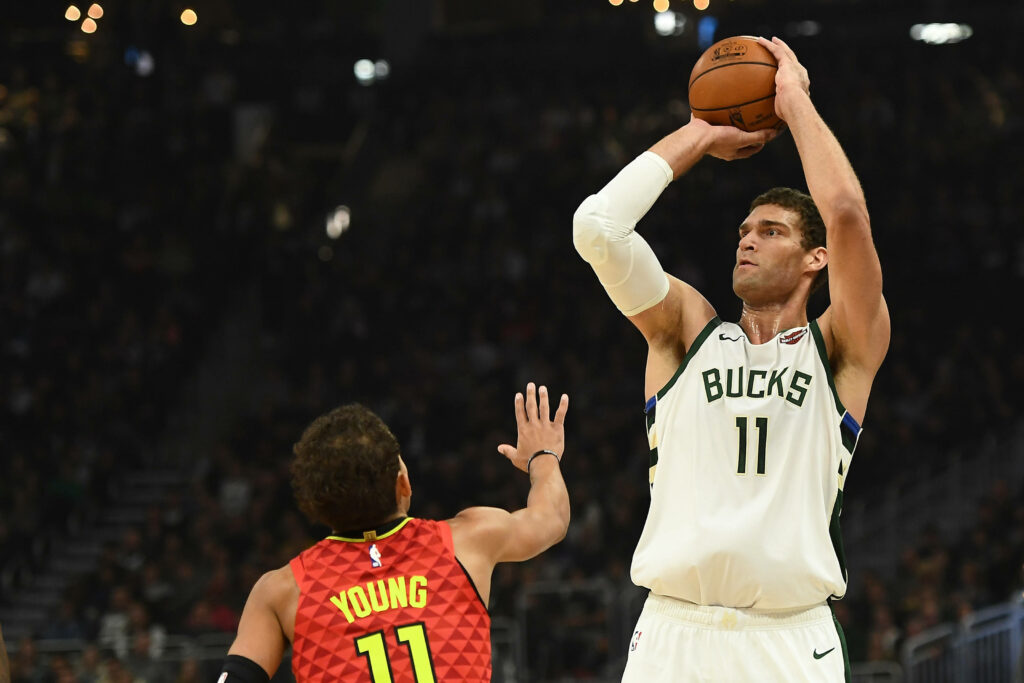 Brook Lopez mid jump shot vs Trae Young NBA intense game action vivid colors basketball wallpaper