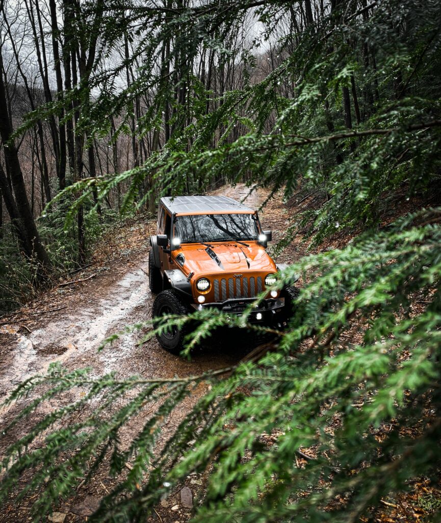 Adventure Awaits: Brown Jeep Wrangler on Rugged Forest Trail Wallpaper