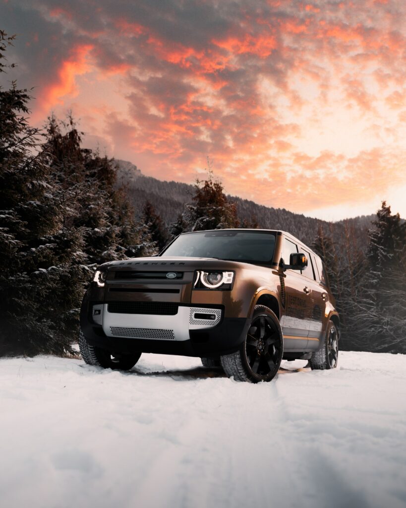Brown Land Rover Defender in Snowy Sunset Landscape Wallpaper