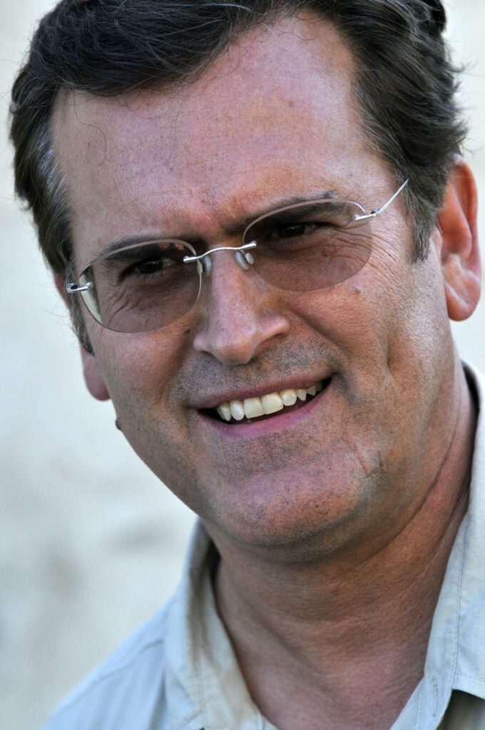 Bruce Campbell close-up portrait with signature glasses casual style natural background wallpaper