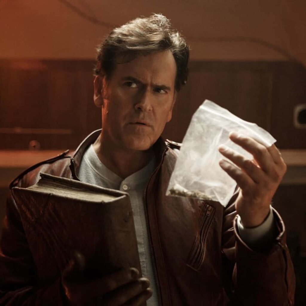 Bruce Campbell dramatic scene leather jacket holding mysterious book plastic bag warm lighting Wallpaper