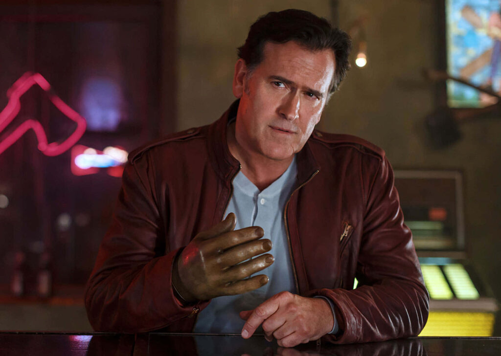 Bruce Campbell in brown leather jacket and metallic glove with moody neon bar background wallpaper