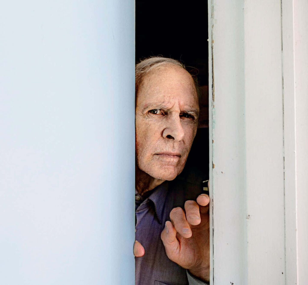 Bruce Dern close-up portrait peering through white door in soft natural light cinematic wallpaper