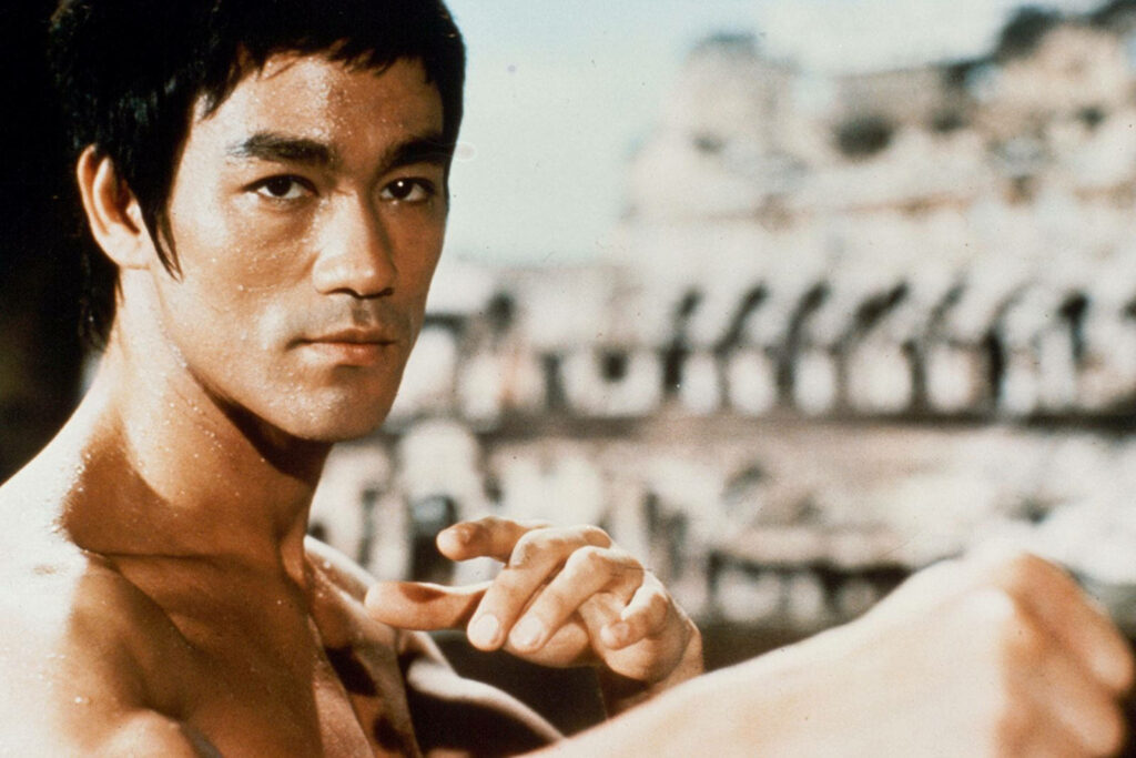 Dynamic Bruce Lee wallpaper showing iconic martial artist in classic fighting stance with focus