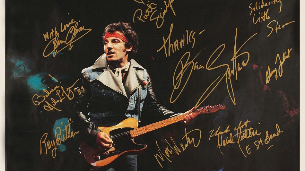 Bruce Springsteen on stage with electric guitar denim jacket red headband E Street Band autographs wallpaper