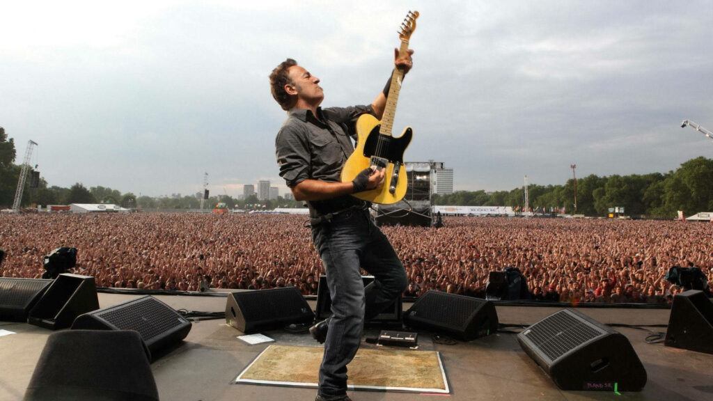 Bruce Springsteen performing energetically with electric guitar at London Calling Hyde Park concert Wallpaper
