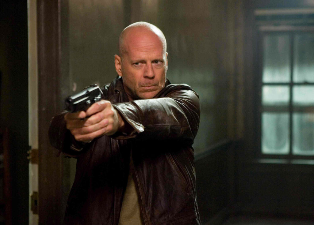 Bruce Willis aiming gun in leather jacket intense action scene iconic thriller wallpaper background