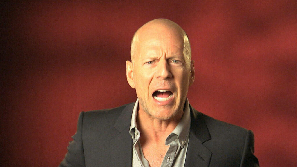 Bruce Willis yelling intensely against bold red background dynamic action movie portrait wallpaper