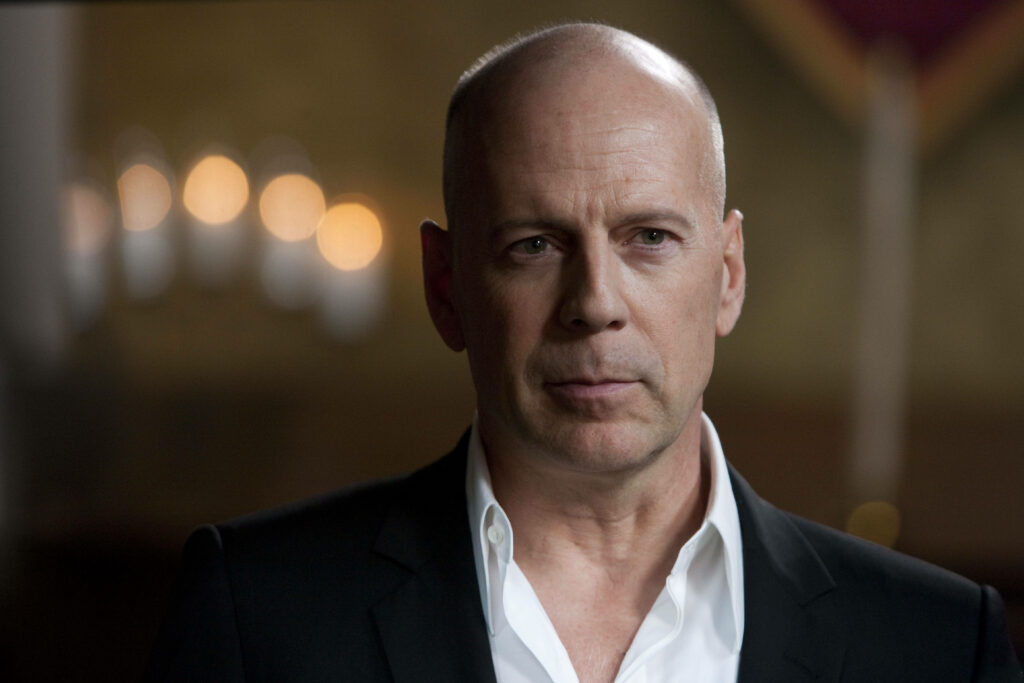 Bruce Willis as Mr Church in sharp suit exuding authority and determination wallpaper background