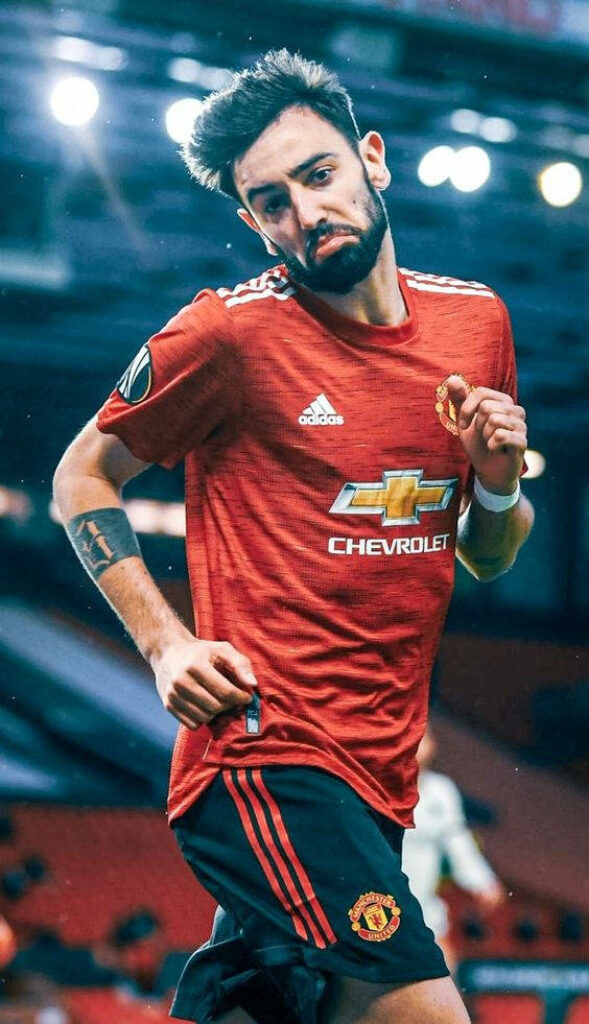 Bruno Fernandes Manchester United midfielder in red jersey action shot stadium background HD wallpaper