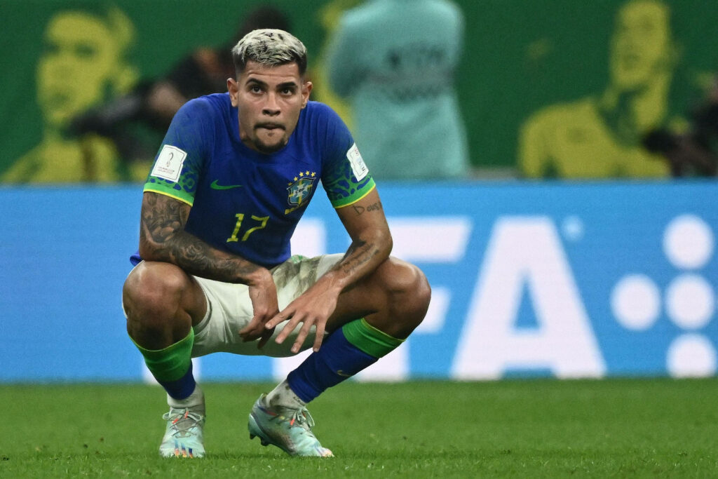 Bruno Guimarães crouching in Brazil jersey intense reflective moment vibrant stadium wallpaper