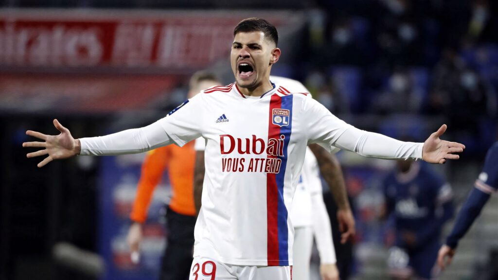Bruno Guimarães celebrates in Lyon kit on vibrant stadium pitch Ligue 1 football action wallpaper