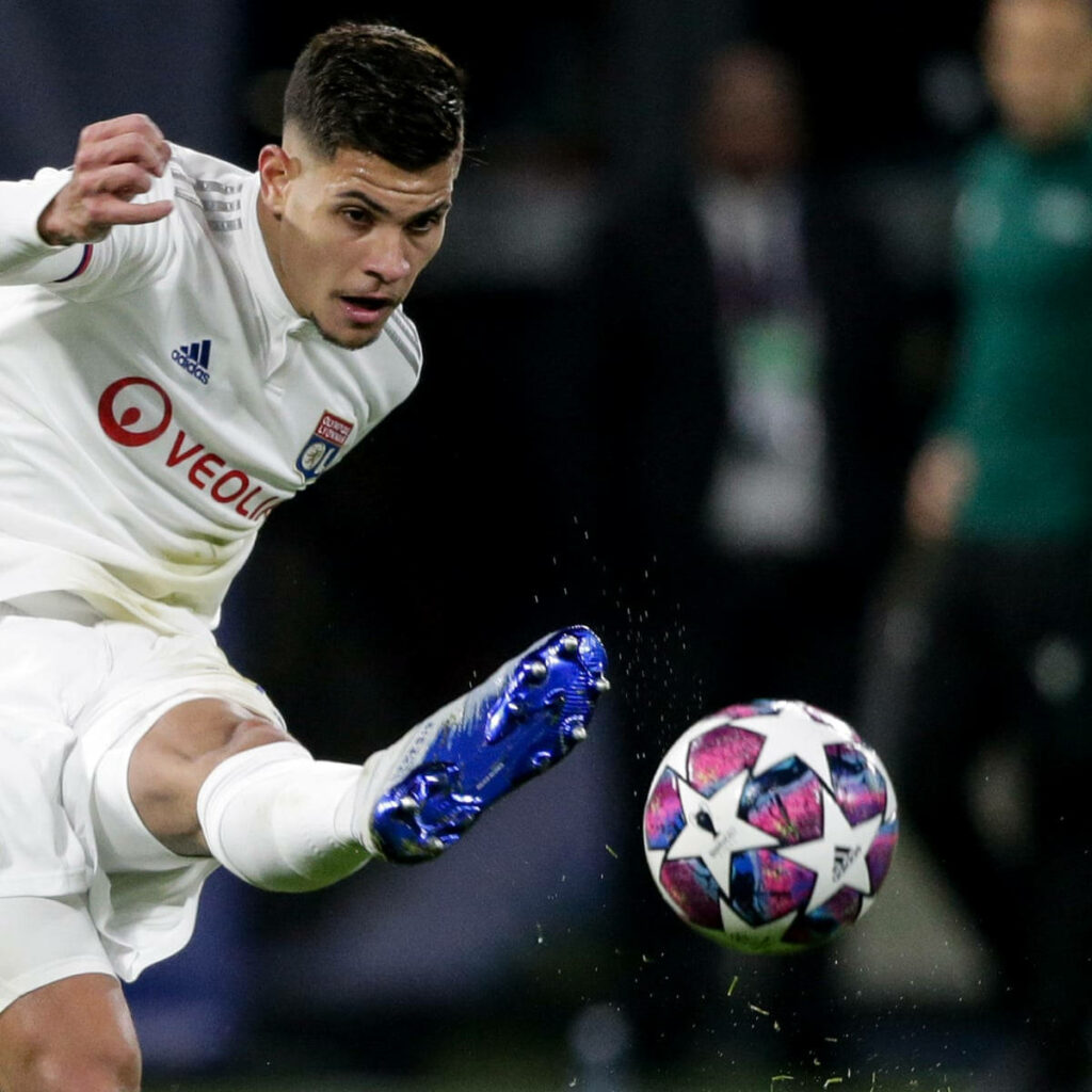 Bruno Guimarães kicking vibrant match ball in white Lyon kit blue cleats intense football action Wallpaper