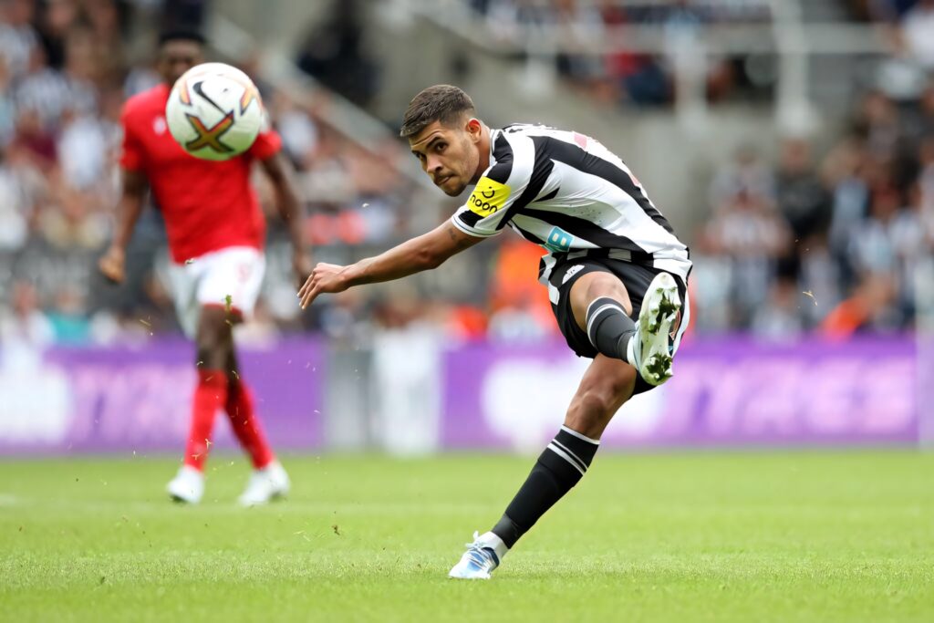 Bruno Guimarães Newcastle United midfielder kicking football with motion blur stadium background Wallpaper