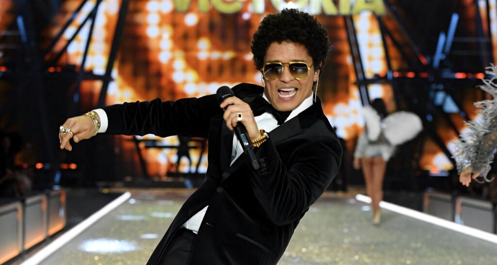 Bruno Mars energetic concert performance vibrant gold black tones stylish fashion wallpaper