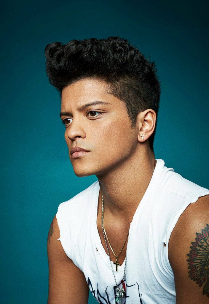 Close up high-resolution portrait of Bruno Mars with classic hairstyle and tattoos on blue background Wallpaper