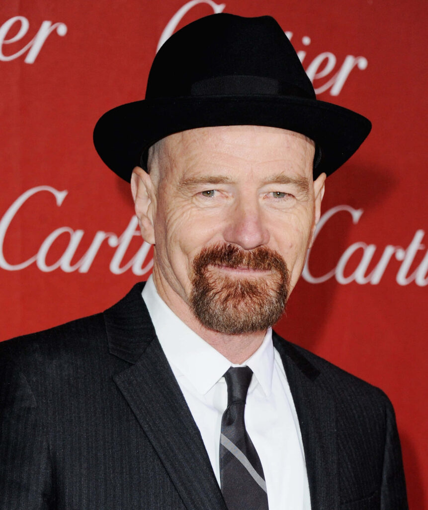 Bryan Cranston in black suit and hat against bold red Cartier background high-resolution portrait Wallpaper