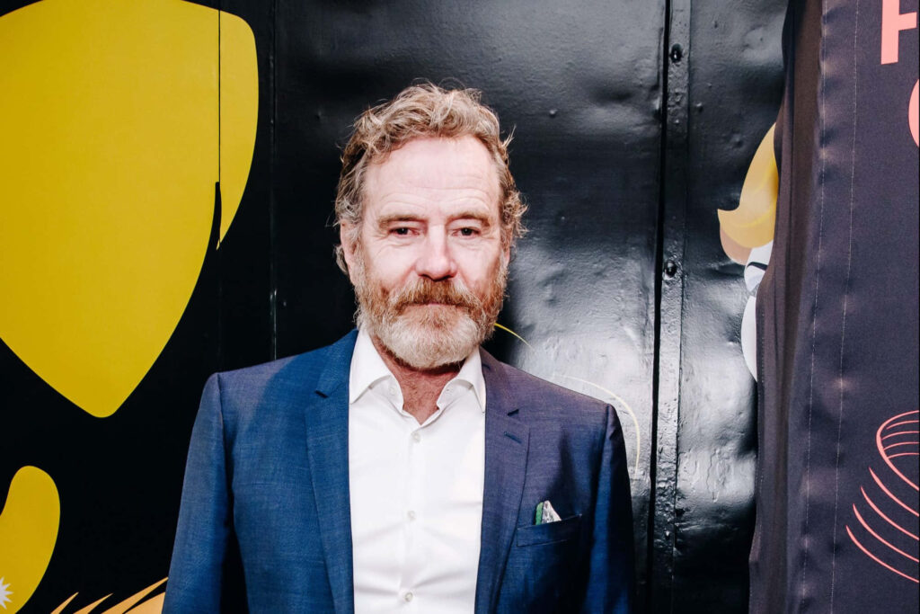 Bryan Cranston in sharp blue suit white shirt artistic black yellow background celebrity wallpaper