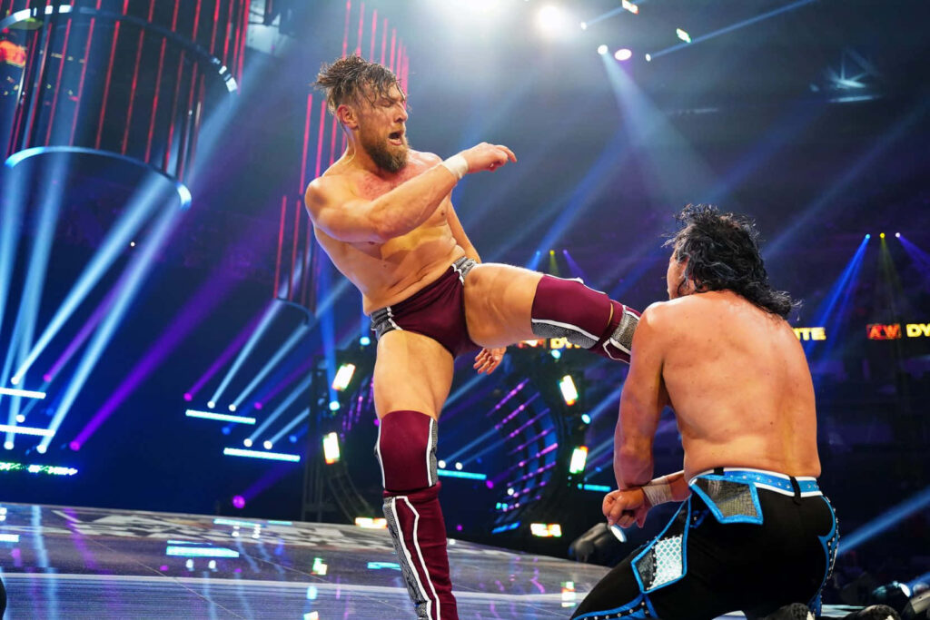 Bryan Danielson AEW wrestler delivering powerful kick intense in-ring action vibrant arena lighting Wallpaper
